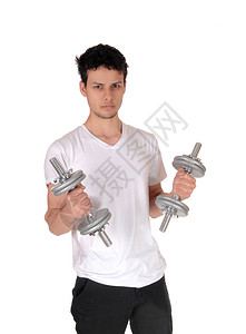 一个英俊的年轻人站在工作室里和两个哑铃一起锻炼腰上部与白种背景隔绝图片