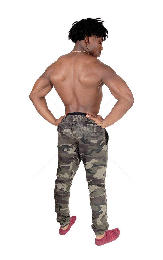 一个年轻英俊的健美运动员站在背边穿着迷彩裤的穿着迷彩裤向下看与白背景隔绝图片