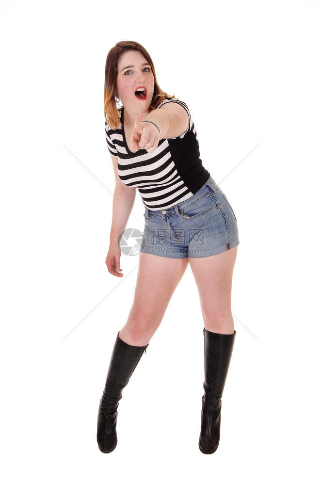一个穿着短裤和黑靴子的漂亮女人指着她的手和喊叫图片