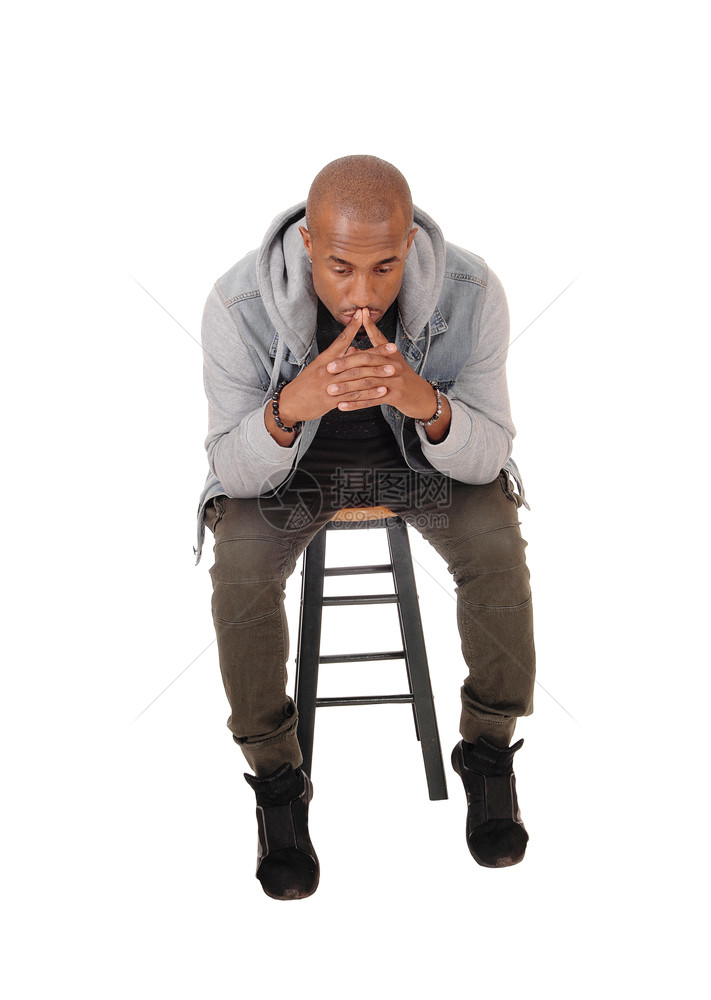 一个年轻英俊的非裔美国人男子坐在椅上手指放在嘴思考孤立于白种背景图片
