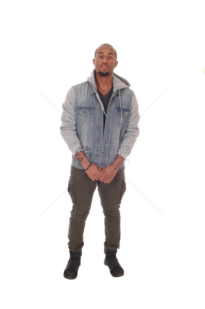 一个英俊的非裔美国人男子站在牛仔裤夹克微笑着双手折叠图片