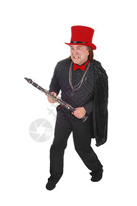 一个身穿黑衬衫裤子和红帽手拿着单簧管打斗的土著人男子因白背景被孤立图片