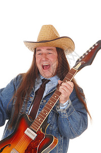 一个穿着牛仔夹克的帅土著男子穿着牛仔夹克和帽弹吉他为白种背景隔离图片