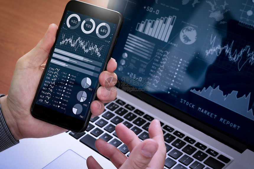 投资者分析股票市场报告和商业情金融仪表板并配有关键业绩指标KPI商人使用智能电话和笔记本脑图片