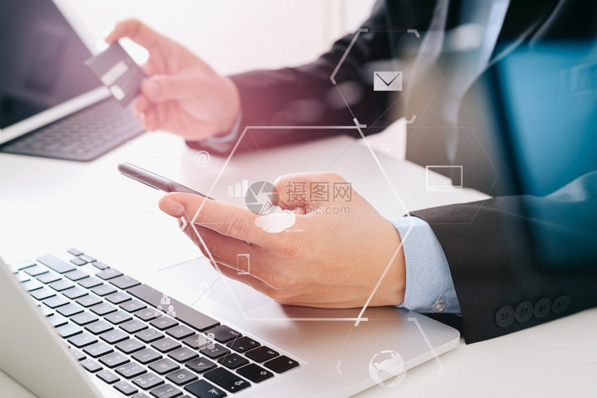商人在网上购买信用卡在现代服务台用移动电话和膝上型计算机VR图标图片