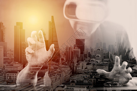 商人在现代办公室佩戴虚拟现实护目镜手机与VR头盔使用与伦敦市接触图片