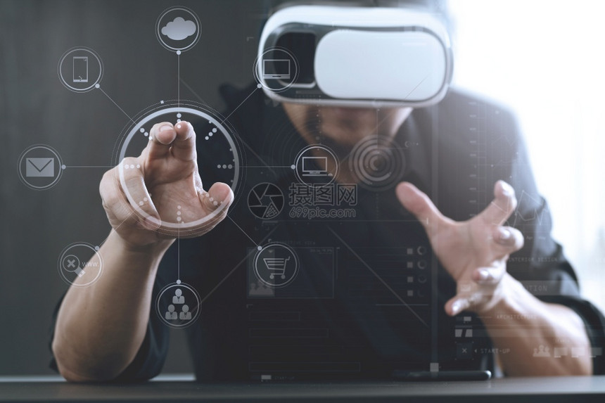 商人在现代办公室佩戴虚拟现实护目镜手持智能机用VR头盔和屏幕图标图片