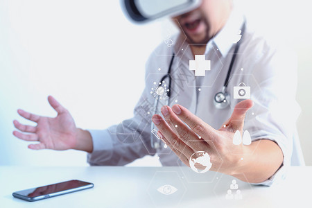 智能医生在现代办公室戴虚拟现实护目镜手持移动电话用VR头盔和屏幕图标图片