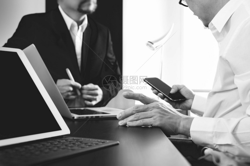 黑人和白现代办公室使用智能电话数字平板脑和笔记本的商人图片