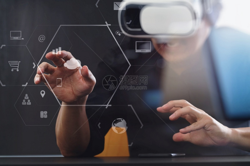 商人在现代办公室佩戴虚拟现实护目镜手持智能机用VR头盔和屏幕图标图片