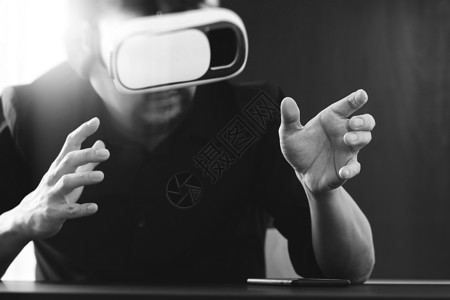 商人在现代办公室戴虚拟VR头盔背景图片