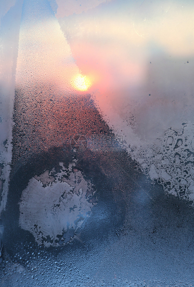 令人惊叹的冰雪模式和水滴在冰冻的窗上在阳光明媚的冬天清晨关闭自然质地图片