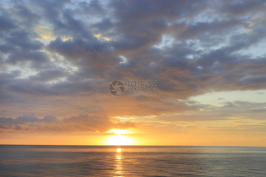 清晨海中日出天空中阳光明亮云彩图片