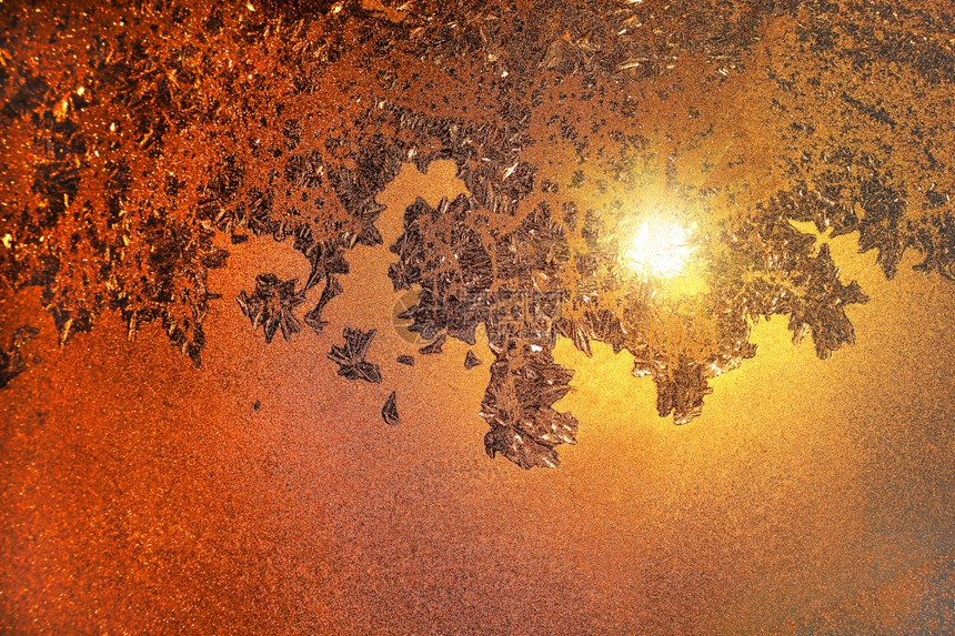 美丽的自然冰面图案和晨冬玻璃上的阳光图片