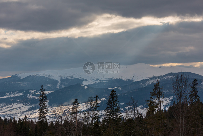 冬雪覆盖的山脊和来自云层覆盖的天空乌克兰喀尔巴阡山斯维多脉的阳光图片