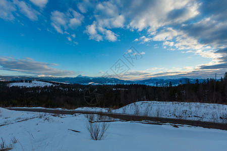 撒尼山口黄昏的冬季云天雪覆盖了阿尔普山脊乌克兰喀尔巴阡山科霍诺拉脉霍维拉彼得罗斯和其他山峰雅布卢尼西亚山口的风景背景