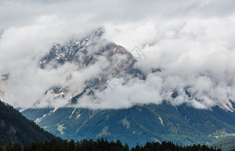 从奥地利费尔南帕斯祖格皮奇山附近的云层上登山顶的图片