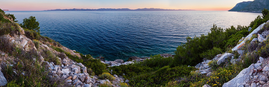 夏季傍晚的海岸线粉色日落和地平线上的岛屿斯通佩列萨克半岛罗地亚图片