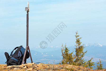 位于山顶的路牌附近旅游背包在春雾的喀尔巴阡山脉背景上图片