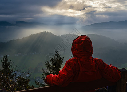 在秋日朦胧的瓦茨曼山上一个不可辨认的休息着的游客在逆光下看着剪影碎片从Marienhohe的观点Berchtesgadener土背景