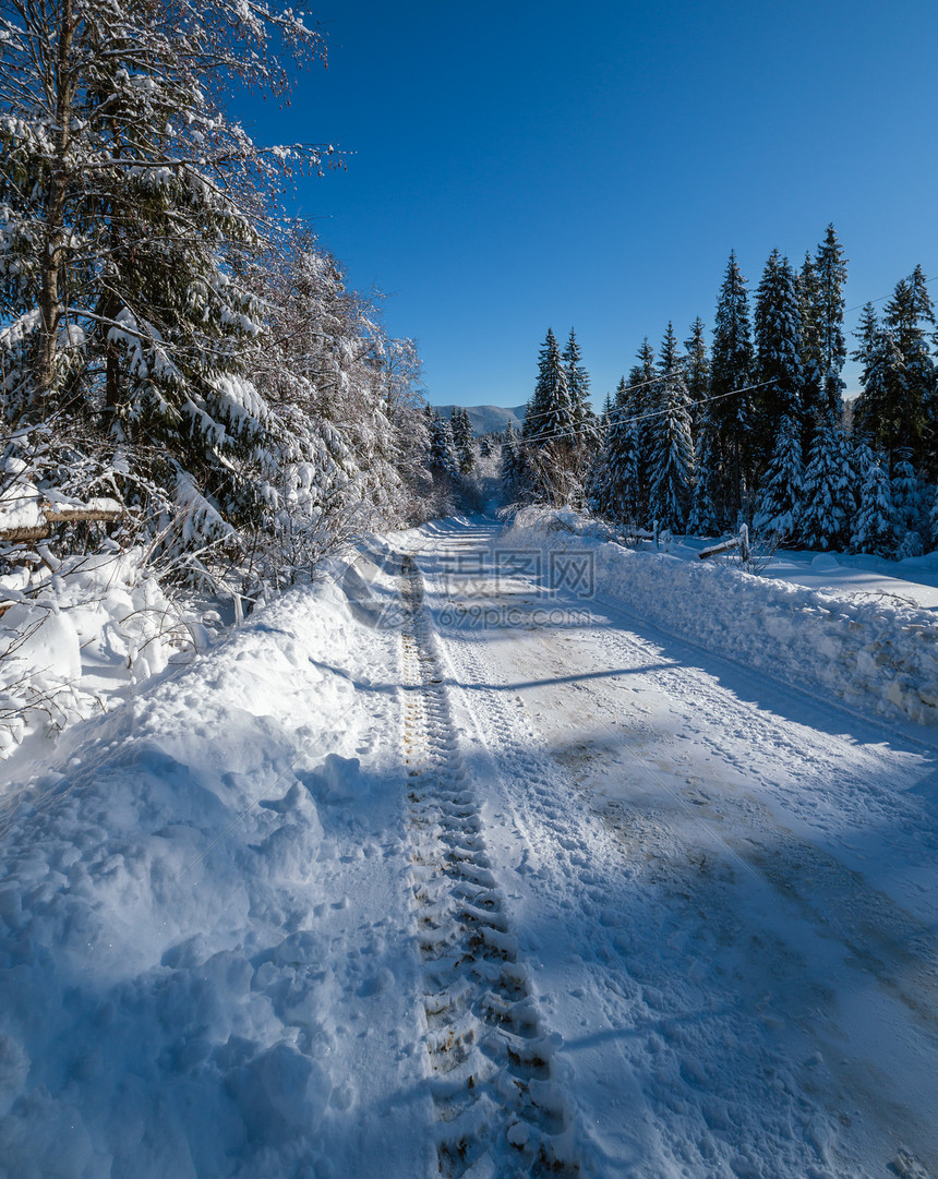 通往边远山区小村庄高的二级公路穿过雪林流和路边的木栅栏图片