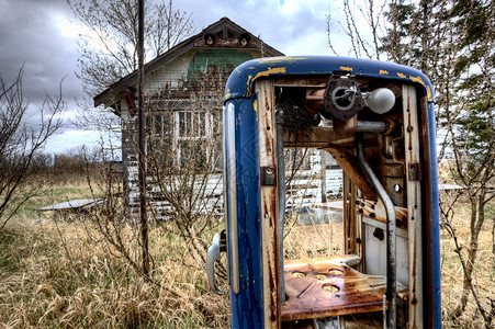 旧式天然气泵和废弃房屋图片