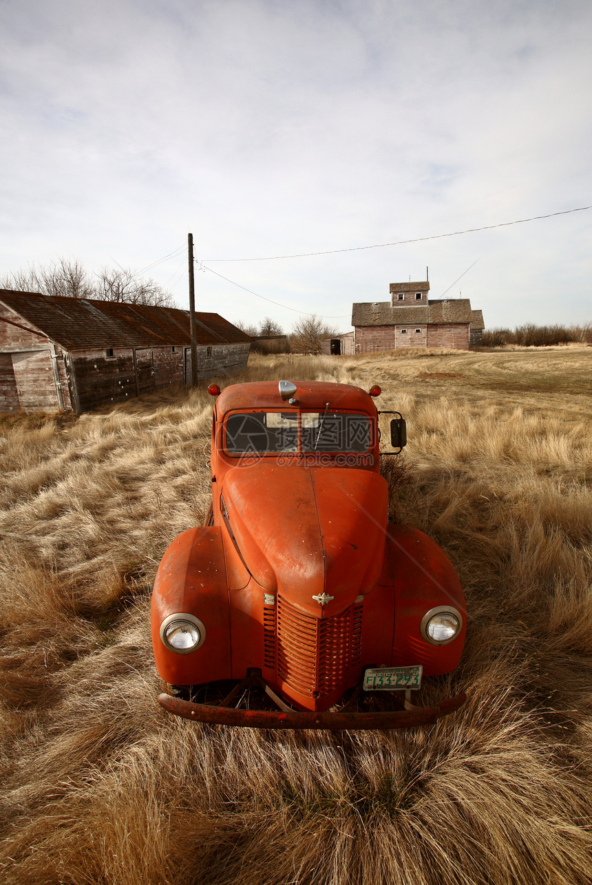 在未用木制建筑物附近废弃的旧农用卡车图片