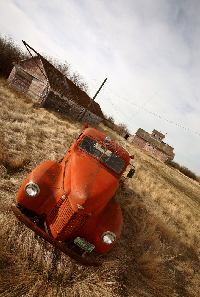 在未用木制建筑物附近废弃的旧农用卡车图片