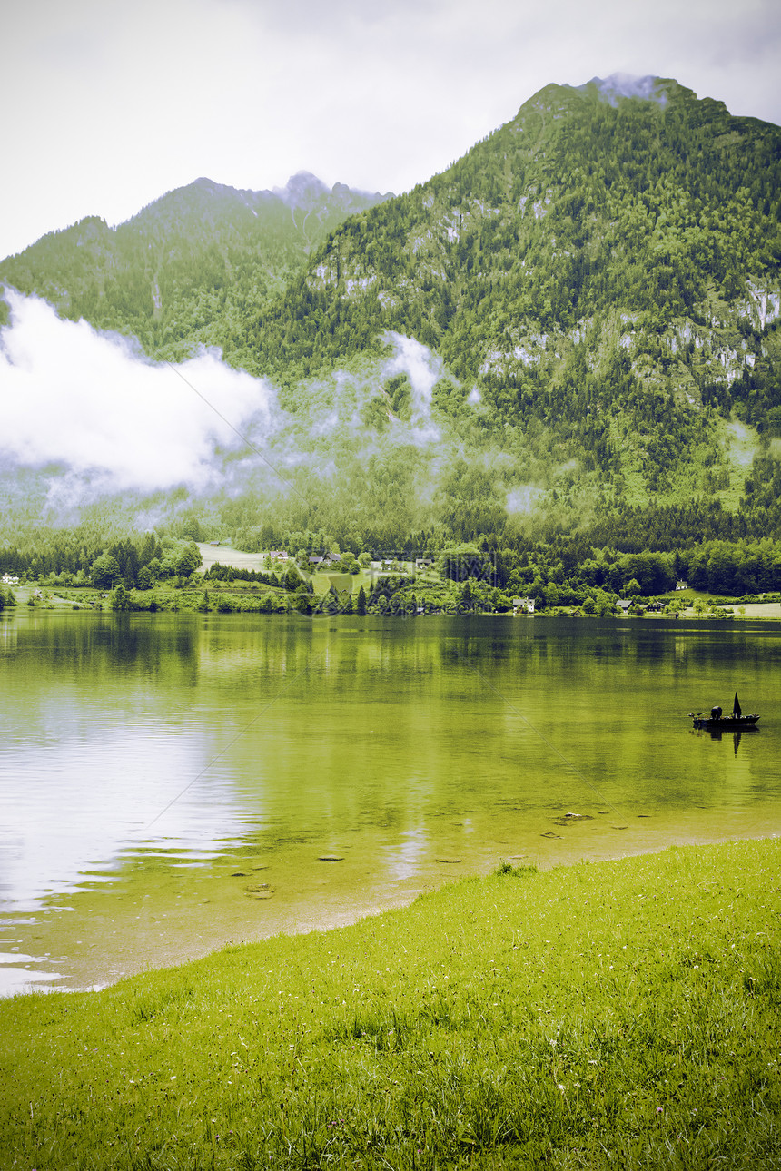 奥地利Hallstattersee的雨和云清晨的雾笼罩在奥地利的风景上有湖森林田地牧场草原和村庄图片