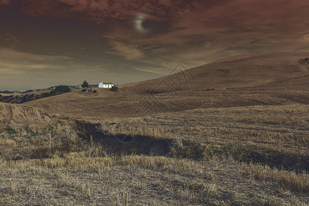 西班牙月亮光照收割后田地上农庄图片