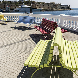 在瓦莱塔河堤岸的多姿彩公园长椅上在马耳他海湾背景上宣传图片