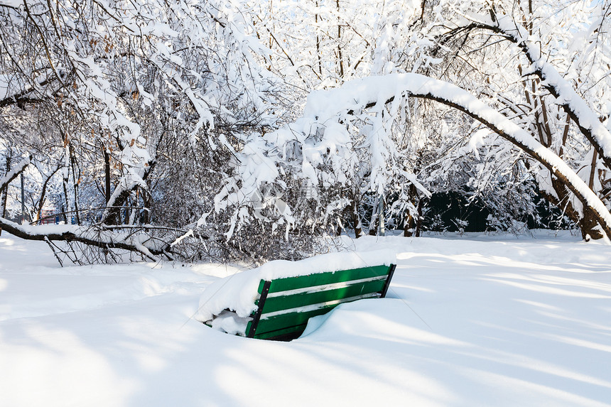 莫斯科市雪的城市花园中覆盖的长椅图片
