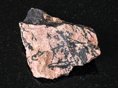 向乌拉尔山的黑花岗岩上发射天然矿物粗鲁罗多尼石图片