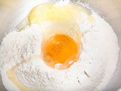 馅饼面粉和碎蛋在钢碗中紧闭图片
