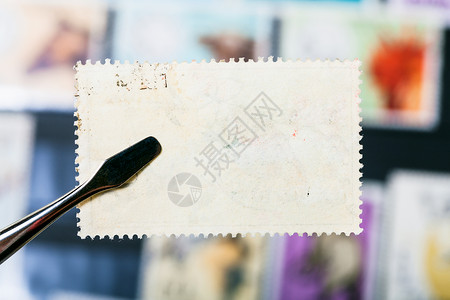 集邮概念在邮票上挂有印章在邮票上贴有未使用的胶背面背景图片