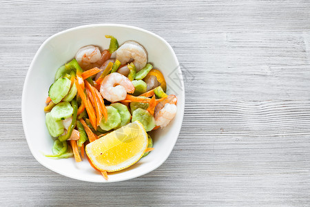 印度菜料季节蔬菜的虾沙拉和白碗的沙拉灰色木板上有免费复制空间图片