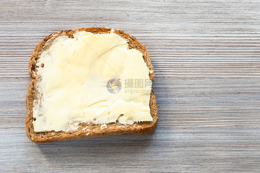 面包三明治的顶部视图灰木板上有黄油空白复页间图片