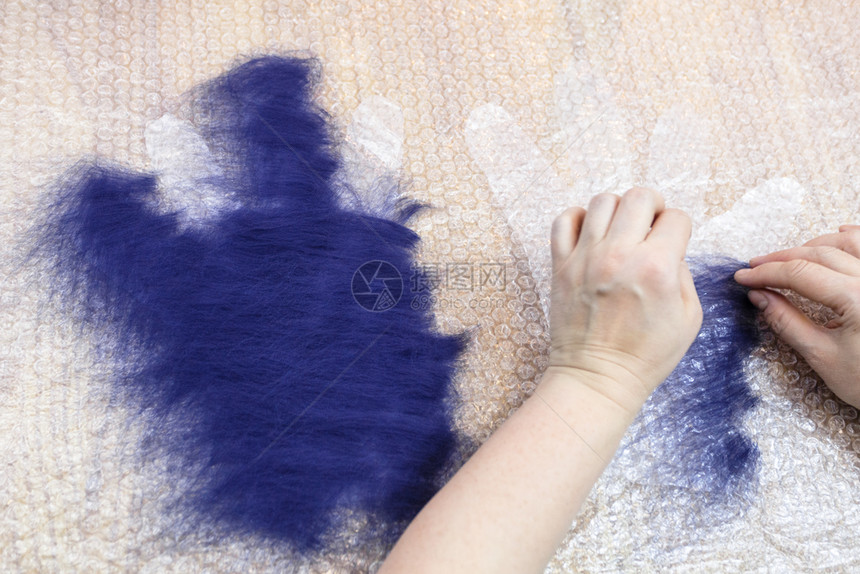 用湿感觉工艺蓝梅里诺羊毛用手套制工艺人将第一层纤维散布在第二层切割模式上图片
