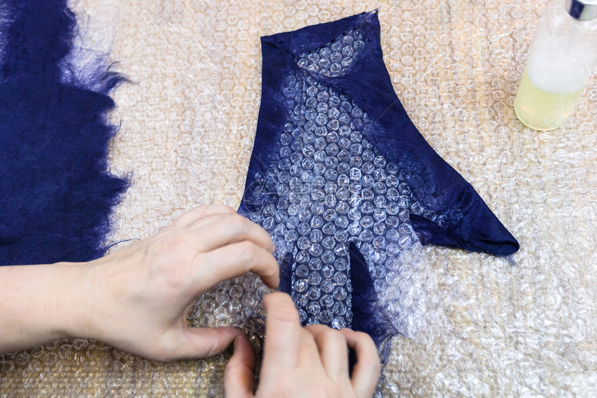 用湿感觉工艺蓝色梅里诺羊毛用手套制工艺人用切割型式手套后侧的纤维制成图片