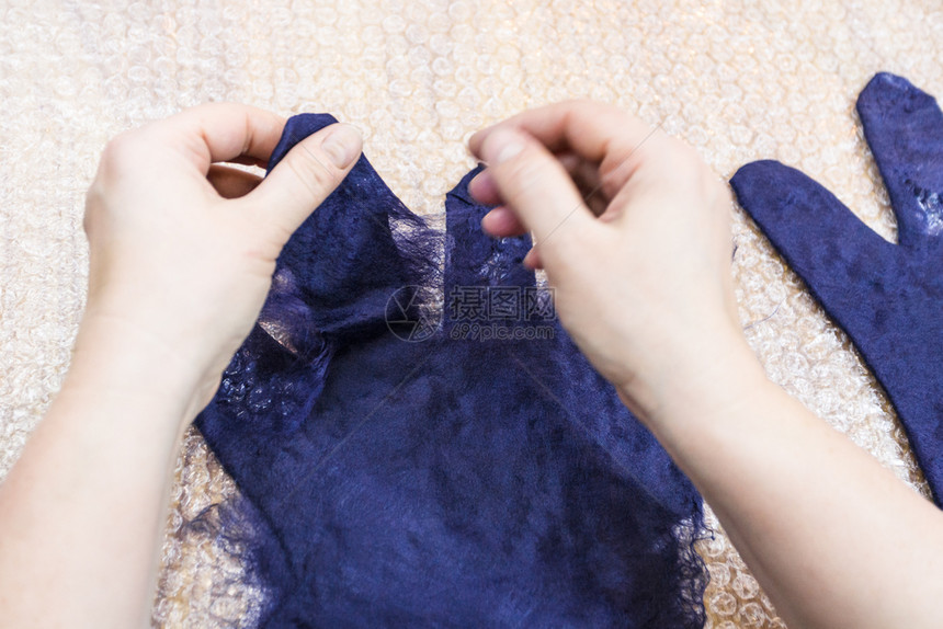 用湿感觉工艺蓝色梅里诺羊毛用制手套工匠用湿纤维制成手套指图片