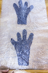 使用湿感觉工艺蓝色梅里诺羊毛手套装在垫子上准备滚动的触摸手套图片