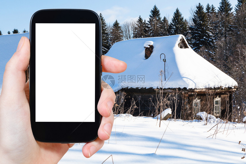 旅行概念俄罗斯莫伦克地区冬季在森林边缘的雪覆盖老农村房子旅游照片用智能手机拍摄屏幕上刻有空白广告位置的屏幕图片