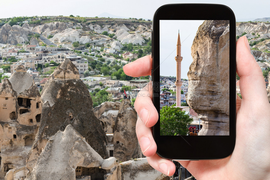旅行概念春季土耳其卡帕多西亚Goreme镇Goreme智能手机古老岩石切割房和清真寺墙的旅游照片图片