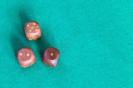 骰子6面3个木制骰子的顶部视图与复制空间一起在绿色浸面桌上各点背景