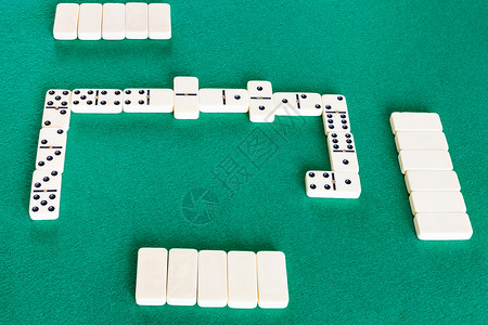 多米诺斯棋盘游戏的玩场绿色面包桌上有白瓷砖图片