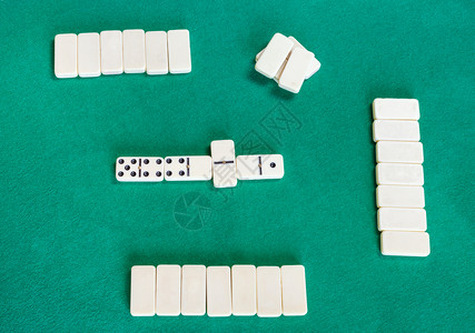 Dominoes棋盘游戏绿色烤桌上有白瓷砖的游戏最上方场视图背景图片