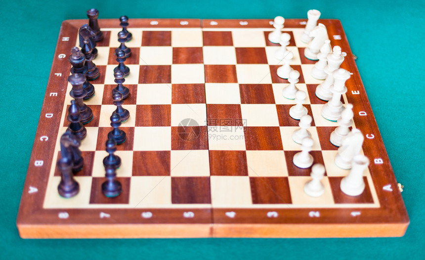 木象棋板其块在绿色烤肉桌的起始位置聚焦于棋盘的中间图片