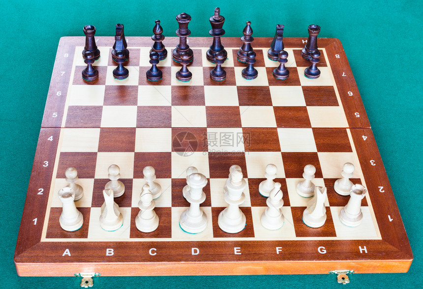 从木形象棋板的白面看象棋碎片在绿色烤肉桌上处于起始位置图片
