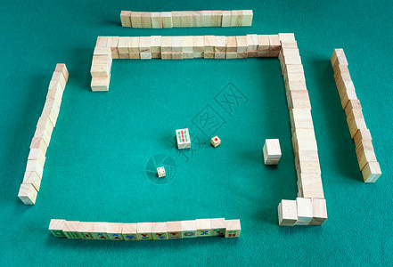 开始打麻将拆卸墙壁在绿色烤肉桌上玩瓷砖战略棋游戏图片