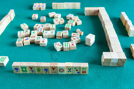 在麻将游戏中玩在绿色烤桌上玩瓷砖战略棋游戏图片